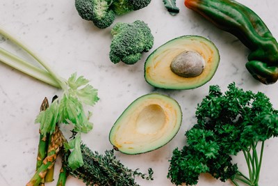 Image of avocados and greens to represent some brain superfoods.