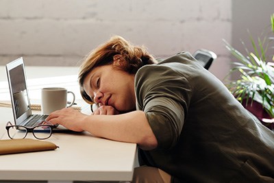 A tired woman, who needs advice on how to improve their energy naturally or could benefit from energy boosting supplements.