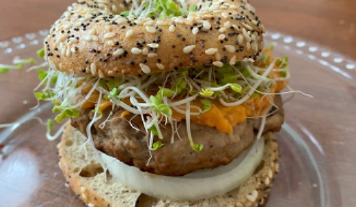 Turkey burger on a bun on a glass plate.